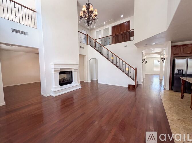 A spacious living room with a fireplace and a staircase.