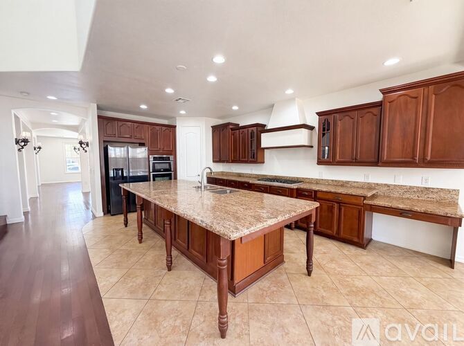 A kitchen with brown cabinets and a granite countertop.