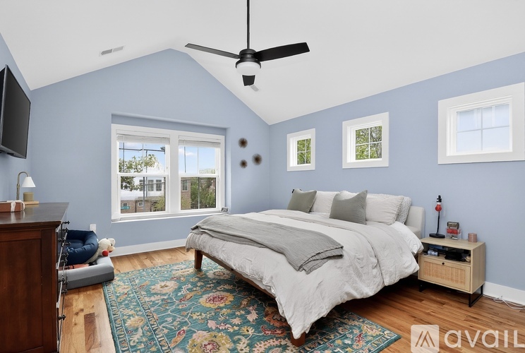A bedroom with a bed, a ceiling fan, and a window.