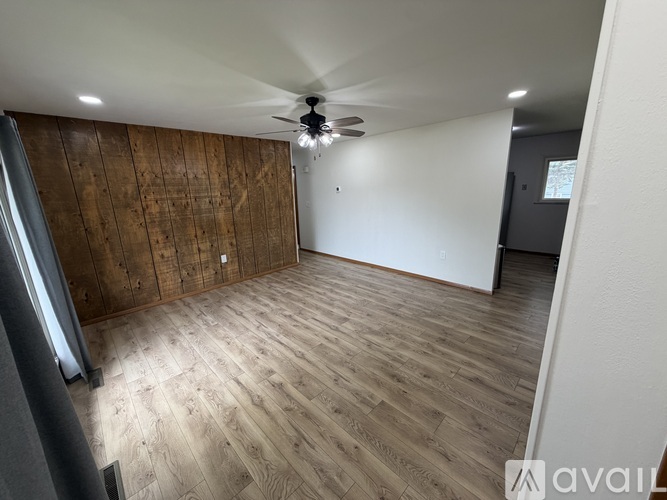 A room with wooden flooring and a ceiling fan.
