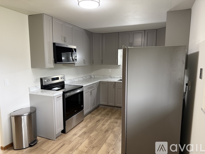 A kitchen with a refrigerator, oven, and microwave.