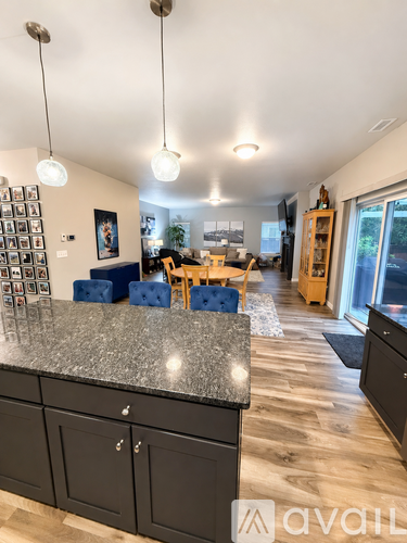 A kitchen with a granite countertop and black cabinets.
