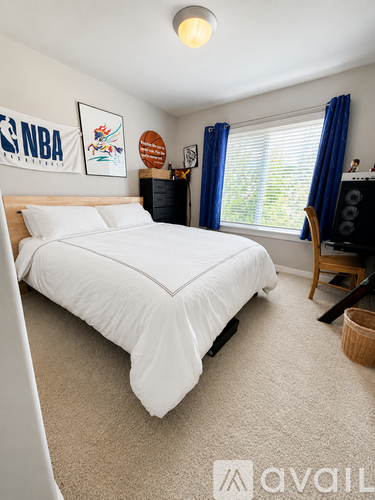 A bedroom with a large bed and a wall decorated with NBA memorabilia.