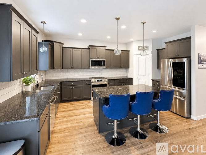 A modern kitchen with dark brown cabinets and a black countertop.