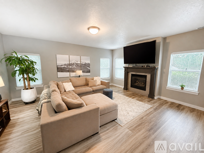 A living room with a large couch and a fireplace.