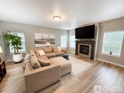 A living room with a large couch and a fireplace.