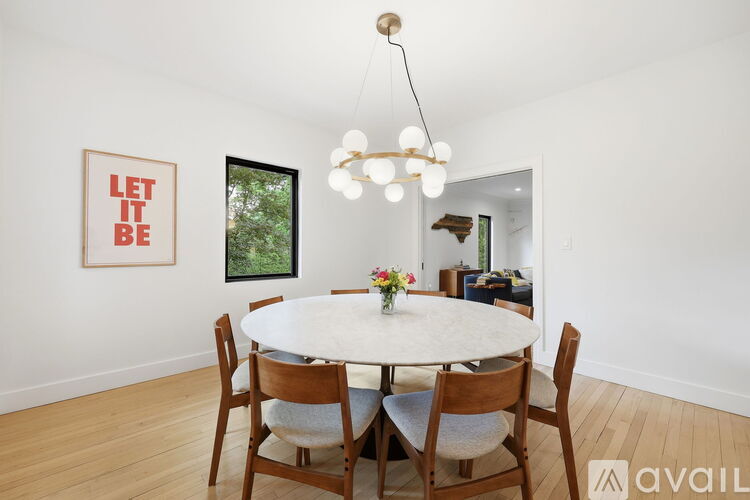 A dining room with a white table and chairs.