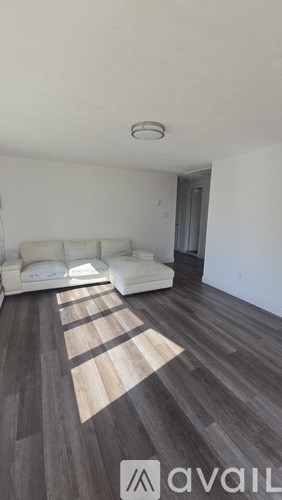 A living room with a white couch and a wooden floor.