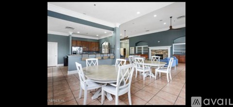 A dining room with a round table and chairs.