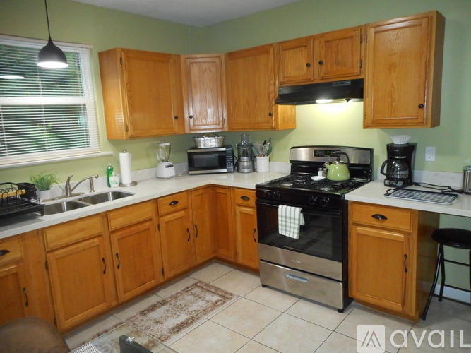 A kitchen with wooden cabinets and a black stove top.
