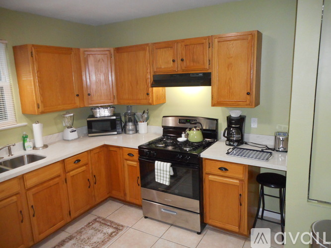 A kitchen with wooden cabinets and a stove top oven.