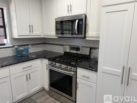 A kitchen with white cabinets and a black stove top.