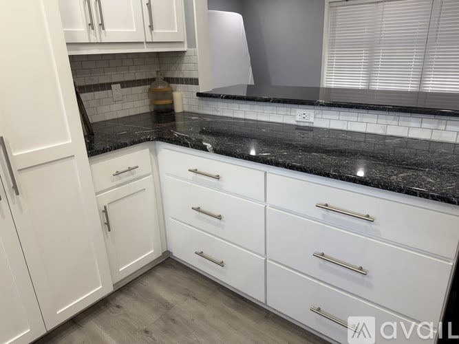 A kitchen with white cabinets and drawers.