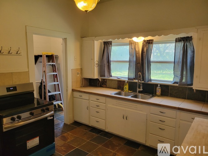 A kitchen with a black stove top oven and white cabinets.