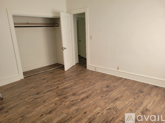 A room with wooden flooring and a white door.