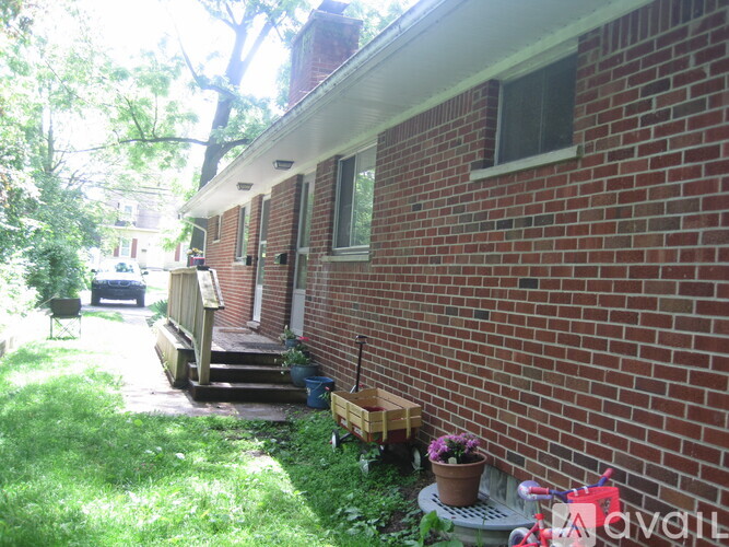 A red brick house with a wooden porch and a small garden.