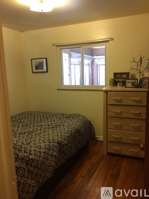 A bedroom with a bed, dresser, and window.
