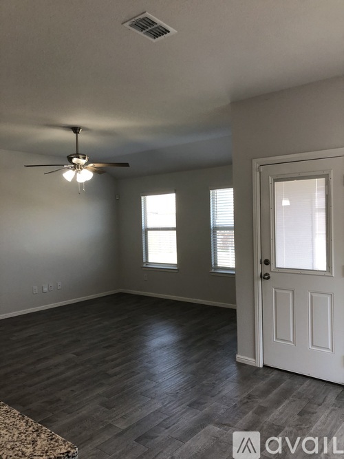 A room with a ceiling fan and a door.