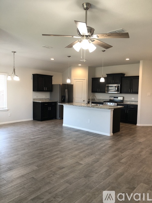 A spacious kitchen with a white island and dark wood cabinets.