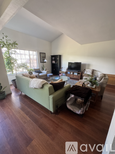 A living room with a green couch and a wooden floor.