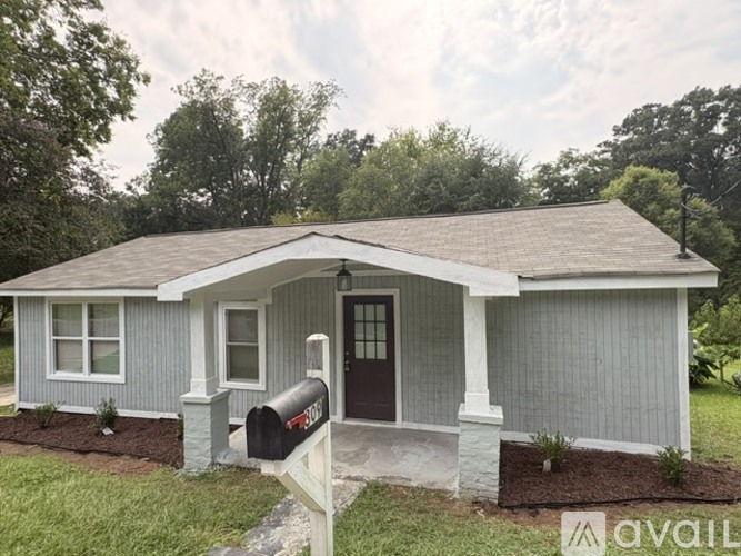 A small house with a mailbox on the front porch.