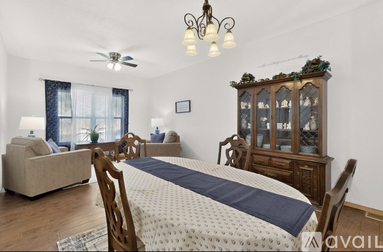 A bedroom with a bed, a couch, a chair, and a cabinet.
