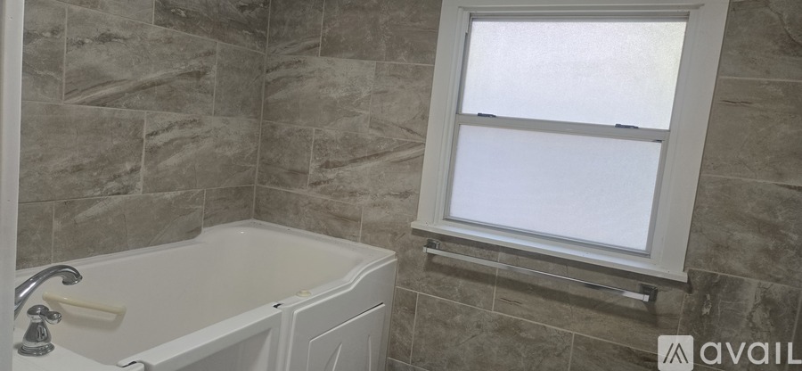 A bathroom with a tub and a window.