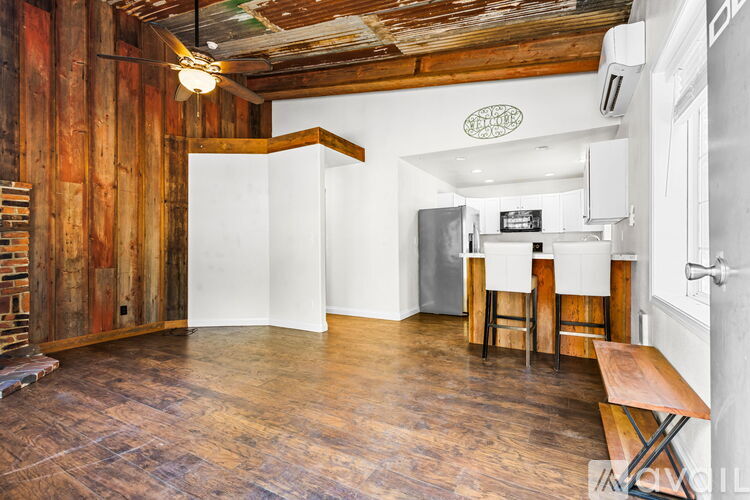 A room with wooden floors and walls, a white ceiling, and a wooden table with chairs.