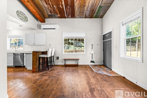 A kitchen with white cabinets and a wooden table.