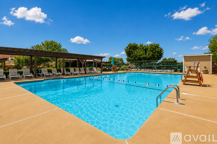 A large outdoor swimming pool with a sun lounger and a shade structure.