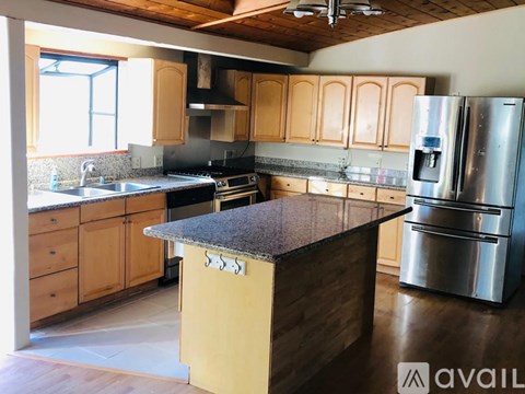 A kitchen with wooden cabinets and a granite countertop.