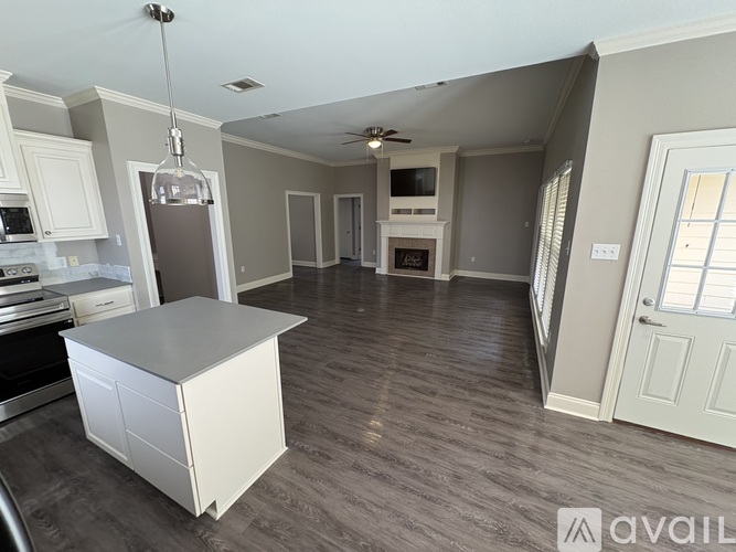 A kitchen with a white island and a refrigerator.