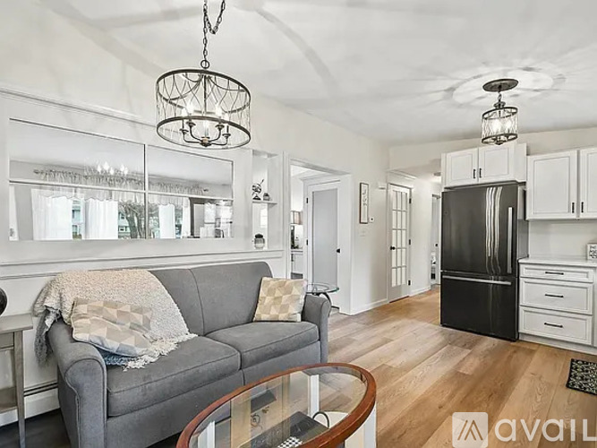 A modern living room with a grey couch and a glass coffee table.