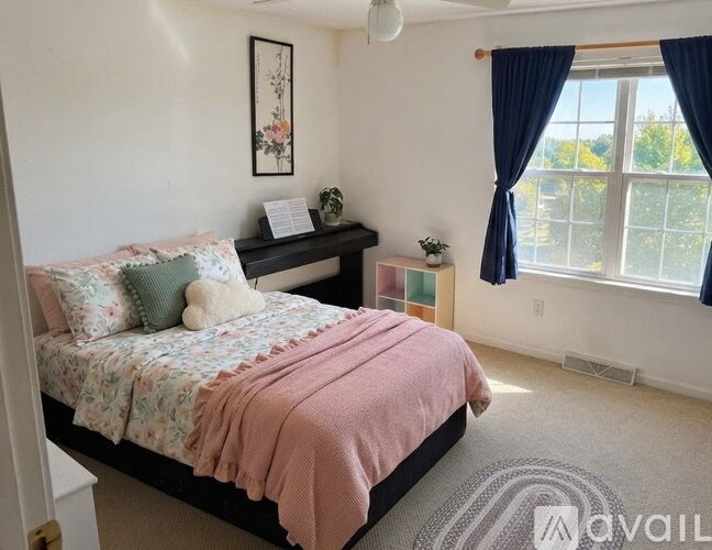 A bedroom with a bed, nightstand, and window.