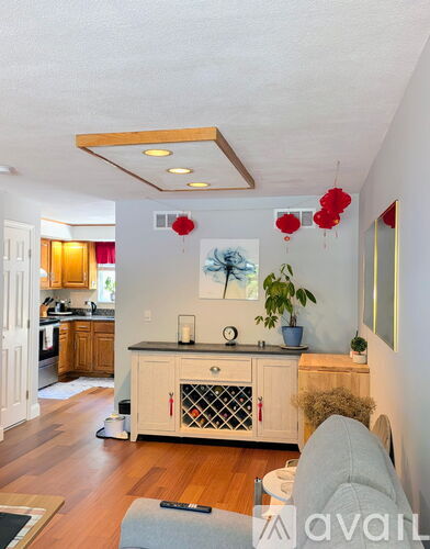 A kitchen with a white cabinet and a grey couch.