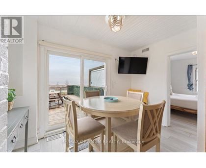 A dining room with a table and chairs and a flat screen TV mounted on the wall.