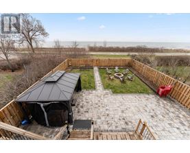 A backyard with a patio, a gazebo, and a view of the beach.