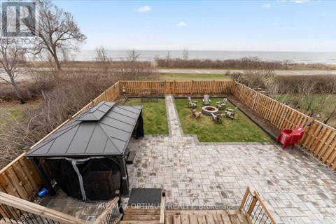 A backyard with a patio, a gazebo, and a view of the beach.