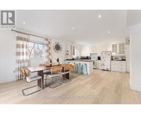 A well-lit kitchen and dining area with a wooden table and chairs.
