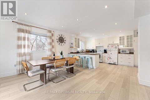 A well-lit kitchen and dining area with a wooden table and chairs.