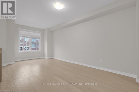 A room with a window and wooden flooring.