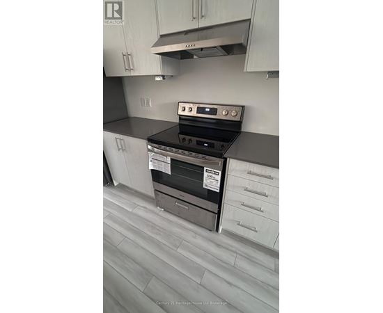 A kitchen with a stove top oven and a range hood.