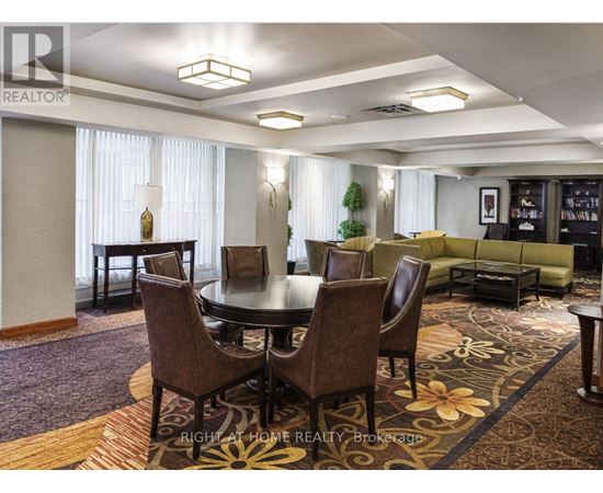 A dining room with a round table and chairs.