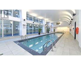 A swimming pool inside a building with a glass enclosure.