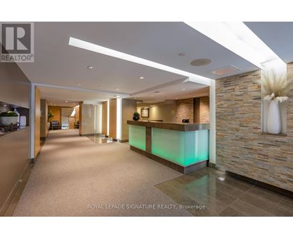 A reception area with a green lighted reception desk.
