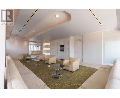 A spacious living room with a white sofa set and a television.