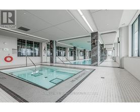 A swimming pool inside a building with a glass wall.