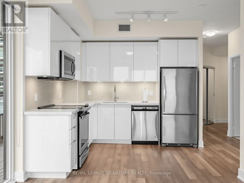 A kitchen with white cabinets and stainless steel appliances.