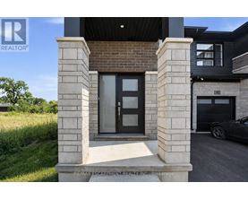 A modern house entrance with a glass door flanked by two stone pillars.