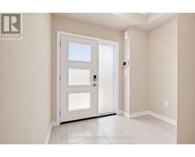 A white door with a window is in a room with white walls.